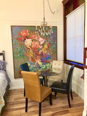 Dining area with chic glass table, comfy upholstered chairs & crystal chandelier