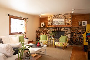River rock fireplace with tons of wood (kindling at front door) 