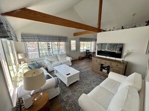 Spacious living room with large waterfront windows and 55" TV
