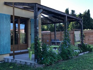 tonnelles en canisses et pergola d'entrée en arrière plan