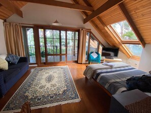 Upstairs queen bedroom with balcony, skylight, TV/DVD player and sofa