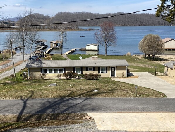 View of front of the house from across the street.  Large concrete driveway.