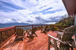 Breathe in the crisp mountain air from this spacious deck. Unwind in Adirondack chairs while soaking in endless Blue Ridge views – perfect for sunrises, sunsets, or stargazing.
