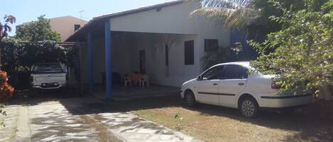 A casa possui uma varanda ampla com espaço para pelo menos cinco carros. 