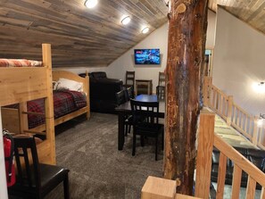 Extra sleeping room, table, couches, and Smart TV in the loft area