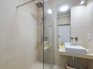 Bright bathroom with washing machine and shower cabin. 