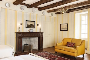 The handsome fireplace and comfy sofa in the Licorne bedroom.