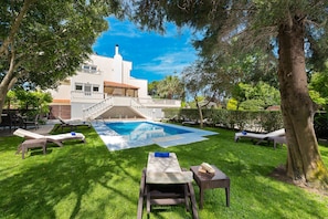 Garden area with swimming pool and sunbeds under the trees