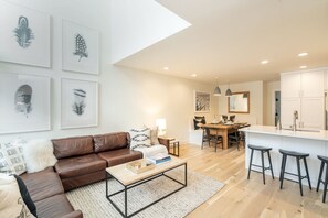 Open living space includes a fireplace, breakfast bar, large sofa and dining area.