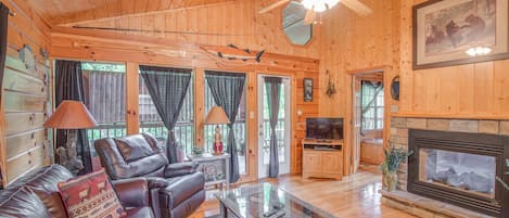A home away from home - Bear Escape’s living room pairs traditional cabin charm—wood-planked walls, floors, and ceiling—with modern comforts including luxe leather seating, a gas fireplace, and a flat-panel TV.