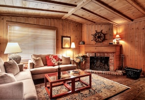 Living room features a high-vaulted ceiling & a wood-burning fir