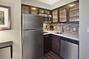 The kitchen features a full sized fridge and freezer and an oven