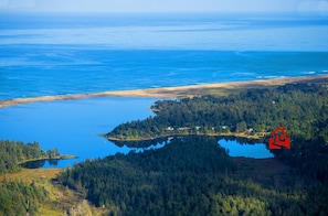 Ariel photo Floras Lake, next to Pacific Ocean. Red house icon location of house