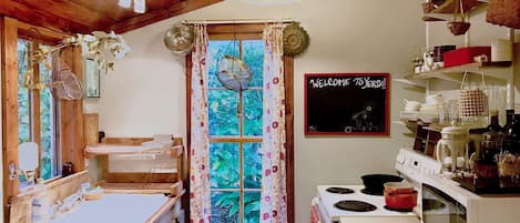 Galley kitchen with range, stove, and microwave.