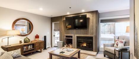 Living Room with 65" Smart TV, Wood Burning Fireplace, Patio Access, and Mountain Contemporary Furnishings