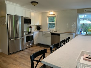 Brand new kitchen with quartz countertops, new appliances and custom cabinets