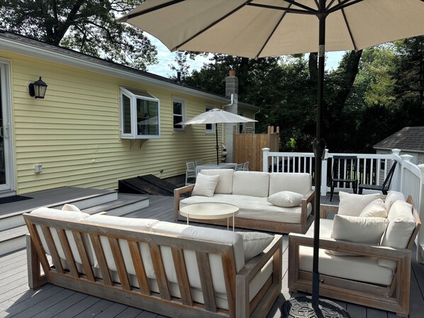 3 tiered deck with couches, table, grill and cedar outdoor shower