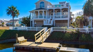 Canal side of home with loads of dercks and furniture
