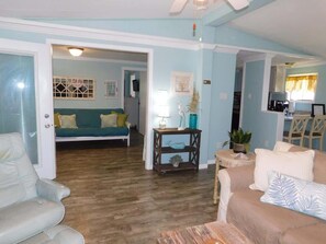 View from family room, sitting room with futon and kitchen to the right