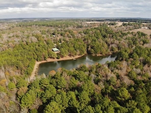 House and the lake surrounded by wooded acreage