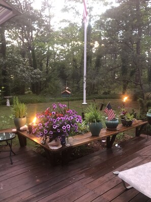 Deck with flowers at dusk, solar lights and torches