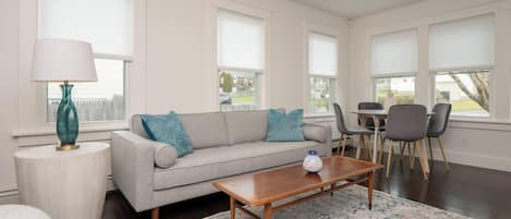 Front photo of living room dining area with new calm coastal furnishings