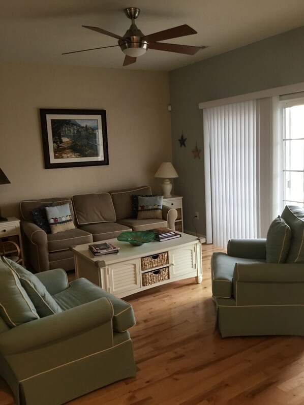 Main floor living room with pull out sofa bed, comfy chairs and 55” hi-def TV.