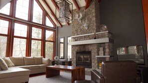 Beautiful open living room with TV, fireplace and high ceiling 