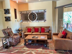 The living area is open plan and updated with designer touches, southwestern decor and leather sofas $ swivel chair