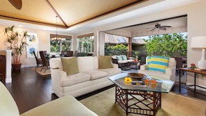 Open concept living area with grass cloth vaulted ceilings