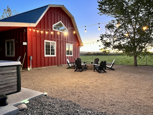 The red barn, fireplace and hot tub to the left. 