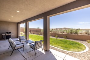 Back Patio View - The Back Patio includes an outdoor dining table, BBQ grill, and sliding glass door that leads into the living room.