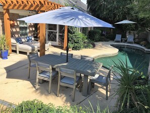Patio table and chairs next to the grill for a convenient cookout.