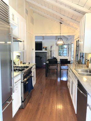 Fully equipped galley kitchen leading into dining room and large living room 