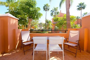 Private terrace with outdoor dining area for four guests and garden views