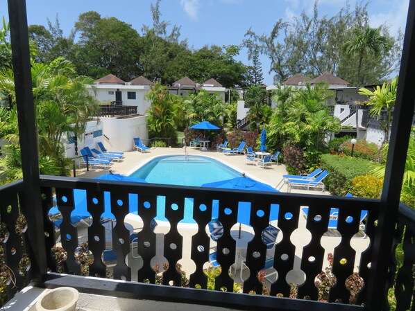 Large shaded balcony overlooking pool, ideal for relaxing or enjoying a meal