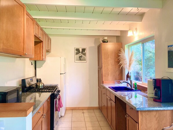 Handsome kitchen with coffee maker, microwave, tea kettle, toaster, pots & pans 
