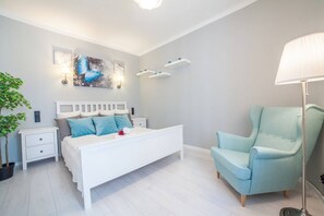 Cozy bedroom with a double bed, armchair and wardrobe.