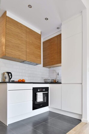 Modern kitchenette with a kettle, fridge freezer, induction hob, oven, toaster.