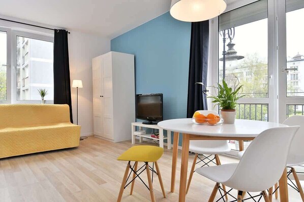 Living room with a comfortable fold-out sofa, a flat-screen TV and an exit to a balcony.