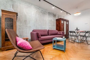 Living room with a fold-out sofa bed, TV, dining area, closet and exit to balcony.