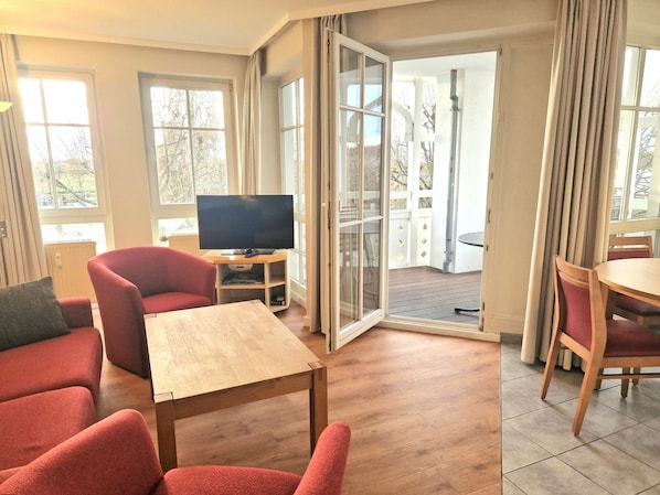 Wohnbereich mit Tv und Zugang zum Balkon