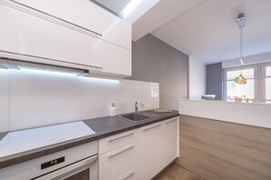 A closer look at the kitchen, highlighting the smooth countertops and ample cabinet space with a minimalist design.