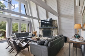 Main room's seating area, fireplace and large smart TV.  View of golf course.