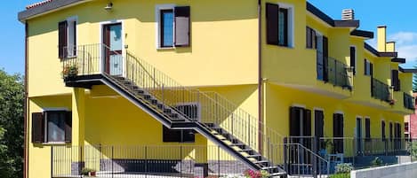 Sky, Plant, Window, Building, Property, House, Yellow, Urban Design, Facade, Stairs
