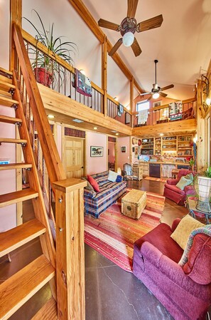 Lodge: View from front door through living room, to kitchen dining.  Ladder to loft at left.