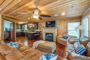 Welcome to our cozy retreat, featuring an inviting electric fireplace, a comfy sofa perfect for a quick cat nap, and an oversized chair that transforms into a bed. Enjoy stunning views from every window