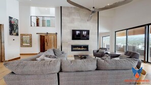 Main living area; modern linear fireplace with oversized flatscreen TV.