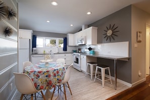 Kitchen within dining table for 4 with additional counter top bar height seating