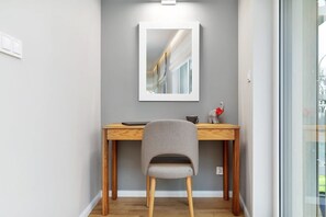 This image focuses on a writing desk with a chair and a decorative mirror above it. The setup is perfect for work or study.